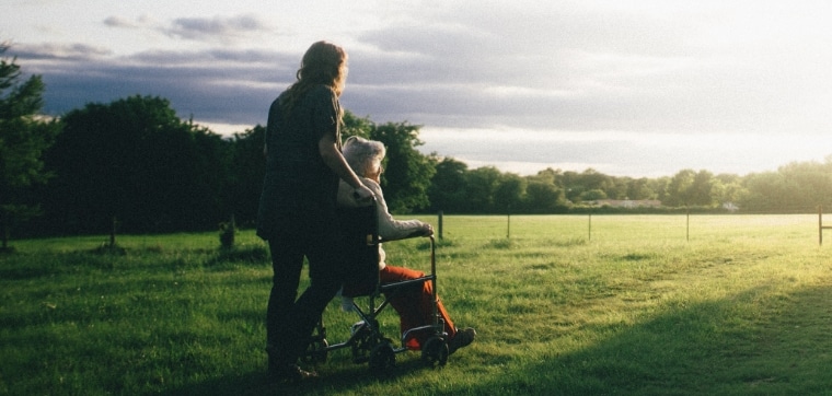 pushing elderly in wheelchair countryside