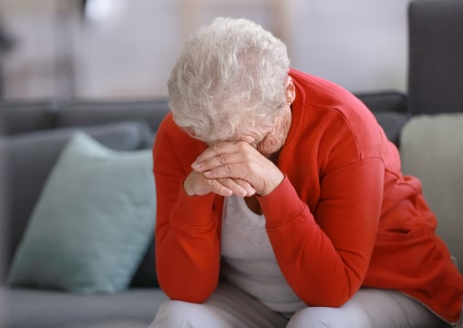Abandoned elder woman crying on couch