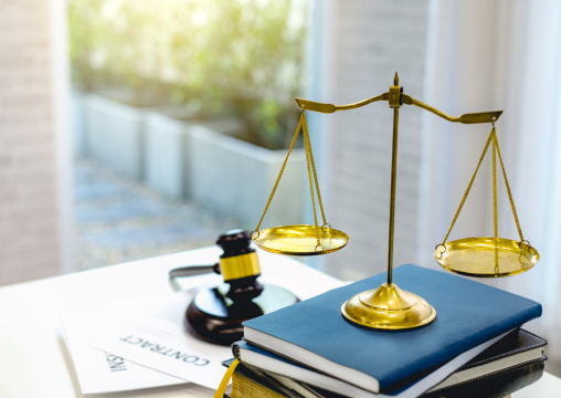 Picture of a gavel and the scales on a table with books