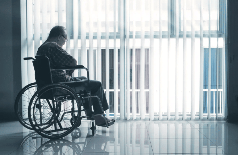 A man sitting on a wheelchair looking outside