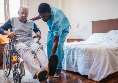 A nurse taking care of an elderly man sitting on a wheelchair